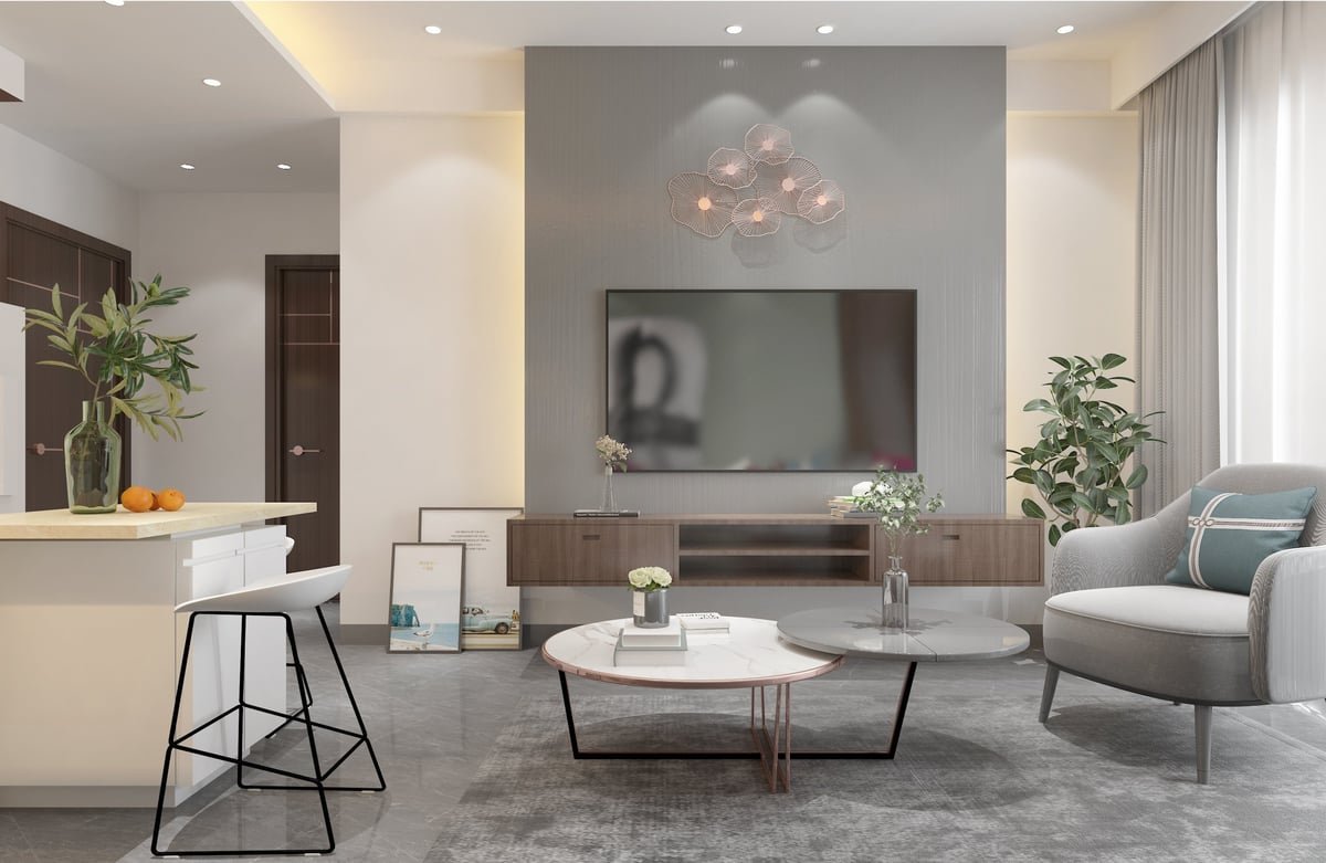 Modern living room with gray walls, wall-mounted TV, gray sectional sofa, coffee table, bar seating, and decorative plants