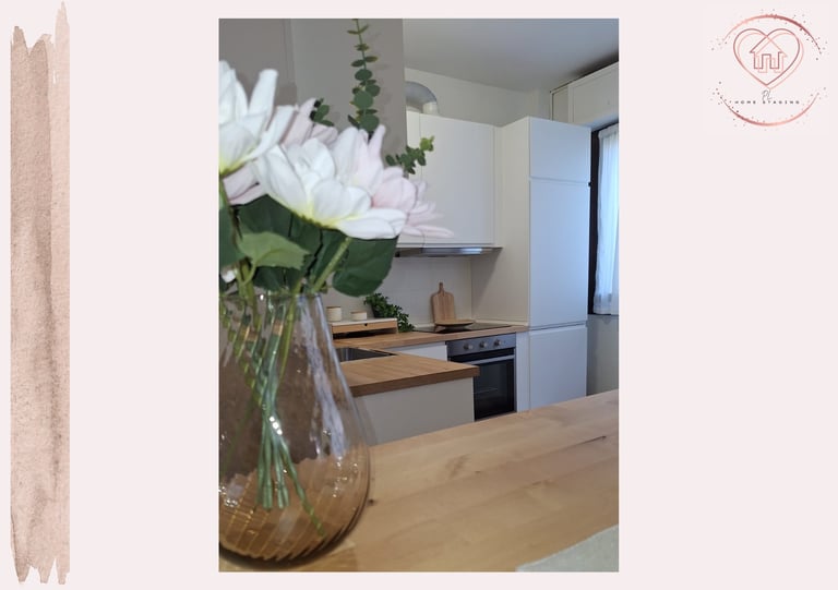 Modern kitchen with white flowers in vase on wooden counter, contemporary cabinetry, and stainless steel appliances